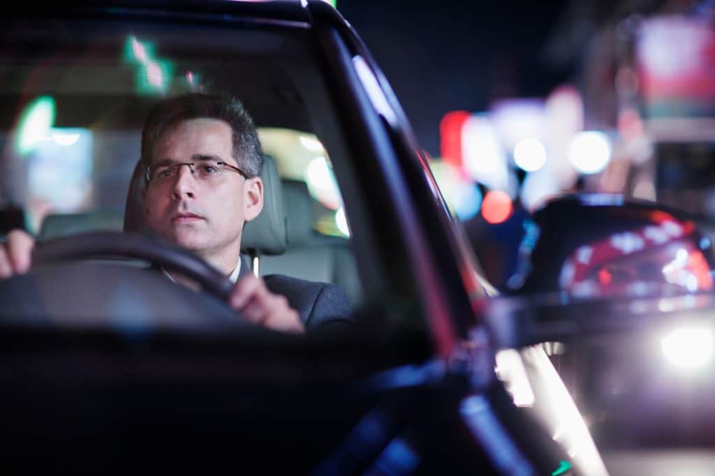 Man driving a car at night.