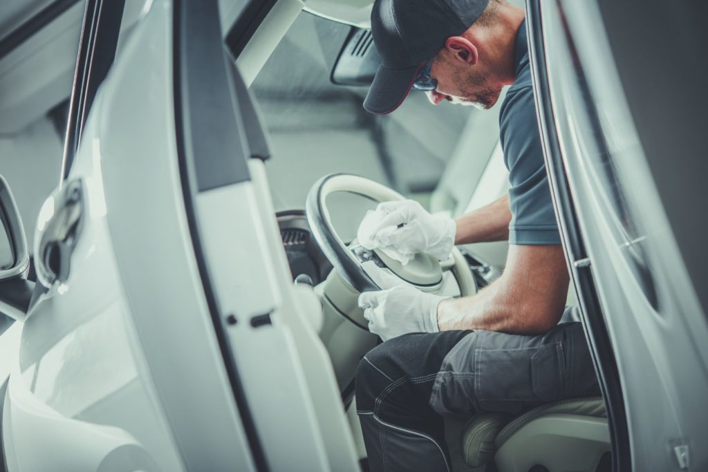 Man detailing the inside of a car.