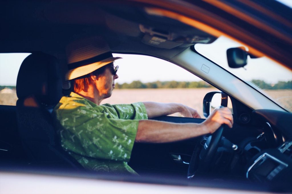 Man driving a car on the open road.